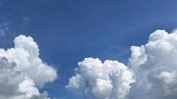 Clear blue sky with fluffy white clouds. The clouds look like scattered cotton, creating a peaceful and calm scenery with Blue sky background. photo