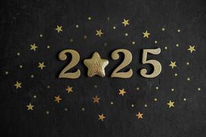 Numbers 2025 on black concrete background, instead of the number 0 there is golden star photo