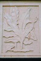 Bogor, November 9, 2024 Stone relief of tropical leaves with textured details in a rectangular frame photo