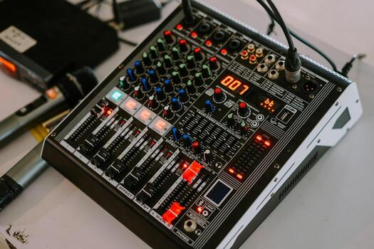 audio mixer soundboard with various knobs, sliders, and indicator lights photo