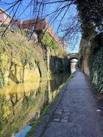 A canal with a bridge and trees on either side photo