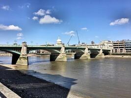 A bridge over a river with a clock tower in the background photo