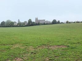 A field with a large grassy area and a church in the background photo