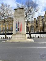 A monument with flags on it in front of a building photo