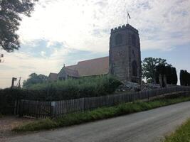 A church with a steeple on the side of a road photo
