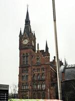 A large building with a clock tower and a bus photo
