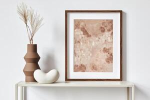 Elegant minimalist interior design with brown mock up poster frame, metal shelf and minimalistic accessories and vase. Copy space. Template. photo