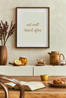 Creative and modern dining room design with mock up poster frame, beige sideboard, dining table and personal accessories. Copy space. Template. Autumn vibes. photo