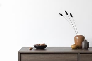 Creative minimalistic composition with white wall and stylish small personal accessories and vases on wooden commode. Copy space. Template. photo