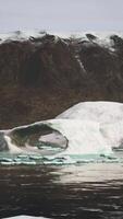 gigantic Ice block structures on the black sand by the sea shore video
