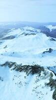 large snow patch left over on the volcanic rock field of a mountain in summer video