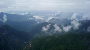 Experience a breathtaking mountain view adorned with soft clouds and vibrant greenery all around. Stock Clip video