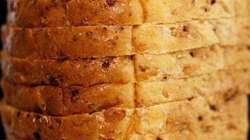 Stack of bread slices of wheat turns on black background video