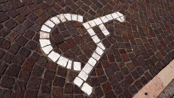 Motion over disabled sign tiled with stones on pavement video