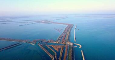 Small asphalt road with cars among endless calm blue lagoon video