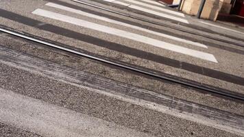 White crosswalk across parallel tram rails on asphalt road video