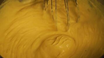 Kneading raw dough with whisk in container at light closeup video