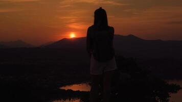 Silhouette of the girl from behind watching the sunset in the mountains video