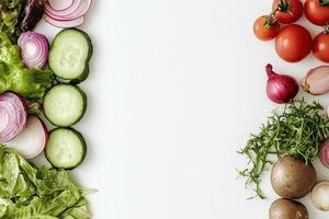 Freshly Sliced Vegetables and Greens Perfectly Arranged on a White Background photo