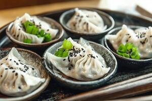 Steamed Dumplings with Scallions and Black Sesame Garnish Served Elegantly photo
