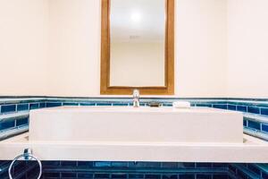 A bathroom with blue tile and a sink photo