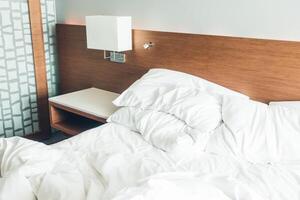 An unmade bed with white sheets and pillows photo