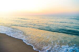 A beach with waves and a sunset photo