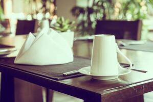 A table with a napkin and a cup on it photo