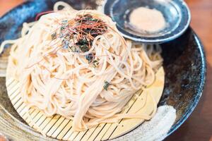 A bowl of noodles with a spoon and a fork photo