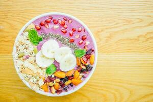 A bowl of fruit and nuts with a banana and a piece of fruit photo