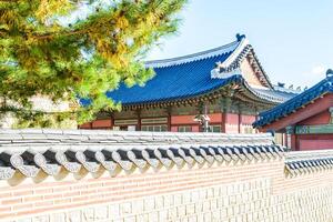A wall with a roof and a building in the background photo