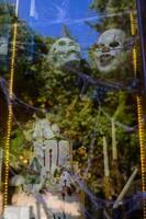 Halloween display featuring eerie clown masks and skeleton decor in a captivating autumnal setting photo