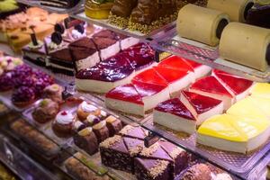 Delightful array of colorful pastries and desserts displayed in a vibrant bakery during afternoon light photo