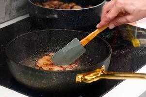 Cooking deliciously golden-brown pork chops on a stovetop using a spatula photo