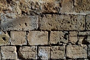 Weathered stone wall with texture and character in a rustic setting illuminated by soft natural light photo