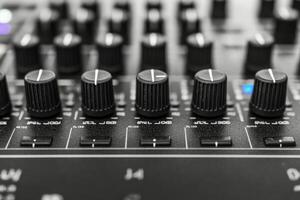 Close up view of audio mixing console with knobs and controls during music production session photo