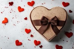 Decorative heart shaped gift box with ribbon and small heart accents on a light background photo
