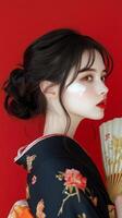 Young woman in traditional attire holding a fan against a red background during a cultural event photo