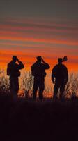 Soldiers salute at sunset while honoring their country with a flag in a mountainous location photo