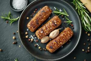 Sliced sausages served on a dark plate with salt and spices creating a gourmet culinary presentation photo