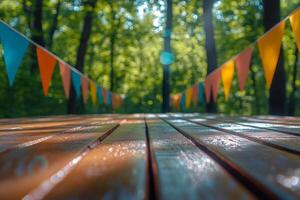 Decorative flags hang above a wooden deck with colorful confetti in a vibrant forest setting photo