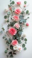 Elegant arrangement of pink and white roses with greenery on a light background photo
