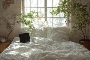 Cozy bedroom with plants, a laptop, and a cup of coffee in soft morning light photo