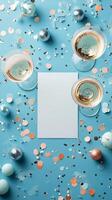 Elegant table setting with champagne glasses and a blank card surrounded by confetti photo