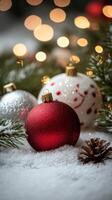 Red and silver Christmas ornaments resting on snow with a soft bokeh background during winter season photo