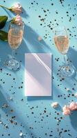 Elegant table setting with champagne glasses and a blank card surrounded by confetti photo