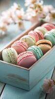 Freshly made colorful macarons arranged neatly in a decorative box on a wooden table photo