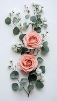Elegant arrangement of pink and white roses with greenery on a light background photo