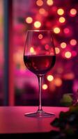 A glass of red wine on a table surrounded by festive decorations in a warm ambiance photo
