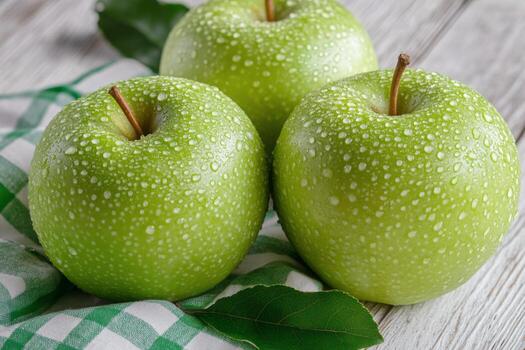 Fresh green apples in a woven basket on a checkered cloth resting on a wooden table photo
